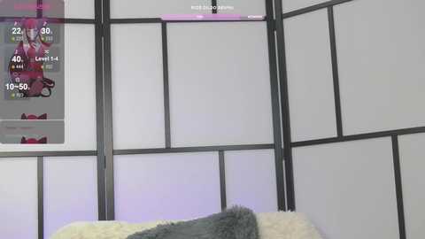 Video of a minimalist bedroom with a black-and-white shoji screen backdrop. A gray blanket and a pink pillow are visible on a bed. A video game screen displays \"22, 09, 04, 51, 10, 55, 50\" and \"GOD MODE ON.\