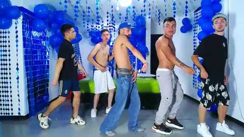 Media: Video of five shirtless, muscular men in a nightclub with blue balloons, one wearing a baseball cap, all in casual attire.