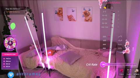 Media: Video of a cozy bedroom with pink lighting, featuring a messy bed with a white comforter, two framed photos of cats on the wall, and a green plant.