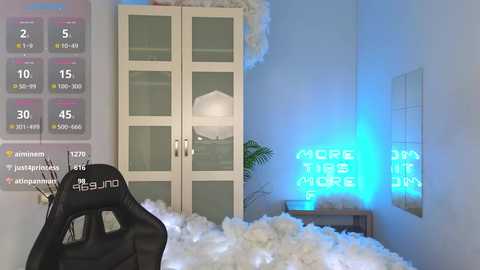 Media: Video of a modern, minimalist room with white walls, a white cabinet, a white lamp, and a neon sign reading \"THE LUCKY ONE\" in blue. A black gaming chair with a \"DUNHIT\" logo is partially visible.