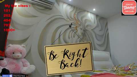 Media: Video of a modern bedroom with a teddy bear, a \"Be Right Back!\" sign, and a detailed, swirling mural.