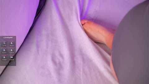 Media: A video of a close-up of a woman's torso, wearing a white shirt, with her erect, circumcised penis partially visible. The background has a purple hue and a small text box with information on the left.