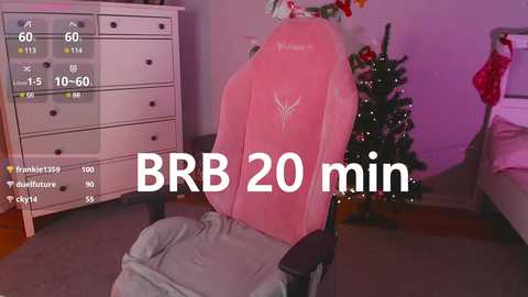 Media: Video of a pink gaming chair in a cozy, dimly lit bedroom with a Christmas tree and a dresser in the background. Text reads \"BBR 20 min.\