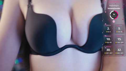 Media: Video of a woman wearing a black push-up bra with a hint of cleavage. Background shows digital stats and a \"Lammy\" character.