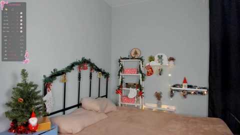 Media: A video of a cozy, festive bedroom with a bed, Christmas tree, white shelves adorned with ornaments, and a calendar on the wall.