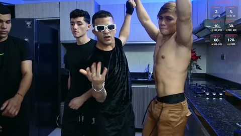 Media: Video of three shirtless men in a modern kitchen, one with a black shirt, another with a black vest, and a third in orange pants, all interacting with a wall-mounted screen displaying fitness stats.