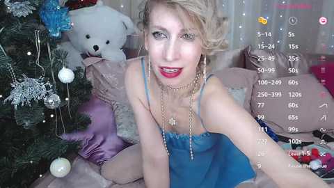 Media: Video of a blonde woman in blue lingerie, posing in front of a Christmas tree, with digital overlays showing live stream metrics.