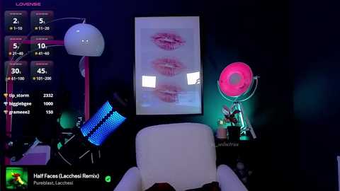 Media: Video of a modern, darkly lit room with a white armchair, a pink light, a pink fan, and a framed close-up of lips. A video game screen shows a character with a half-finished facial tattoo.