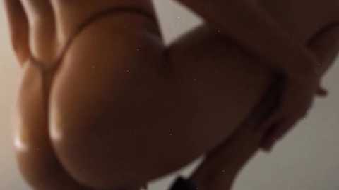 Media: A blurred, close-up video of a nude person, likely female, with visible buttocks and a hand gripping their thigh. The background is out of focus, creating a soft, diffused lighting effect.