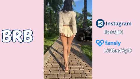 Media: Video of a young woman with long black hair, wearing a beige crop top and short skirt, walking barefoot on a stone path. Background includes palm trees and a car. Social media icons on right.