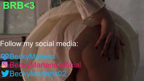 Media: A video featuring a woman in a sheer, white, long-sleeved dress, her right hand on her exposed hip, revealing her bare skin. Text overlays include \"Follow my social media\" and \"BeckyMarten's official.\