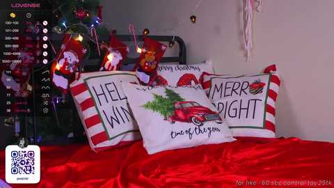 Media: Video of a festive bedroom with a red bedspread, white pillowcases featuring \"Merry Christmas\" and a red truck, and a Christmas tree in the background.