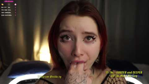 Media: Video of a fair-skinned woman with red hair and dark makeup, performing oral sex on a penis, with a blurred background and text overlay.