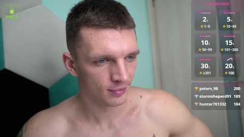 Media: Video of a shirtless, light-skinned, young man with short brown hair and a slim build, indoors with a teal wall and a soccer ball.