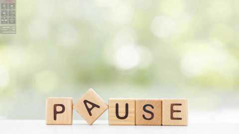 Media: A video featuring a wooden letter puzzle spelling \"PAUSE\" on a white surface, with a blurred green background, emphasizing tranquility and relaxation.