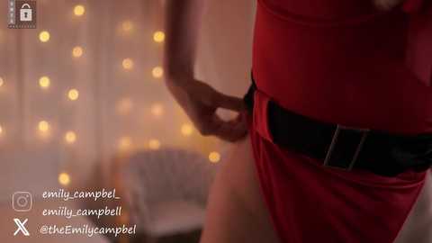 Video of a woman's waist in a tight red dress with a black belt, against a softly lit, blurred background. Text overlays: \"@Ewwillycampbell @Ewwillycampbell @Ewwillycampbell @Ewwillycampbell.\