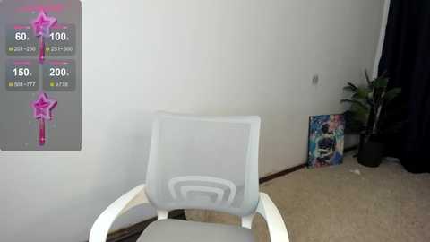 Media: Video of a modern white office chair with a mesh backrest in a minimalist room with white walls, a potted plant, and colorful artwork on the floor.