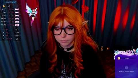 Media: Video of a person with long, wavy orange hair, wearing black-framed glasses, elf ears, and a black choker, in a dimly lit, red and blue-striped room, with a video game UI overlay.