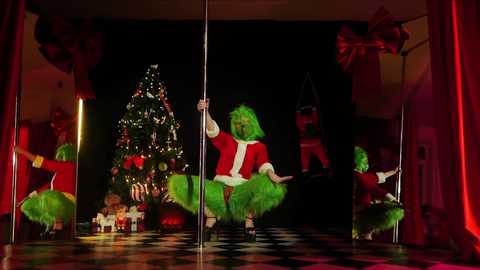 Media: Video of a green-haired Santa Claus pole dancer on a black-and-white tiled stage, surrounded by Christmas decorations and a performer in a red suit and hat.