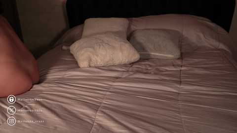 Media: Video of a dimly-lit bedroom with beige bedspread and two white pillows. A bare foot is partially visible on the left side.