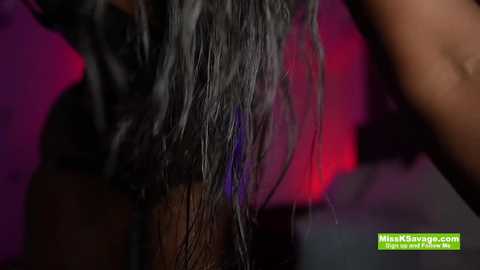 Media: Close-up video of a person's shoulder-length black hair being dyed blue with a dark purple tint in a salon, showcasing the wet strands and vibrant colors.