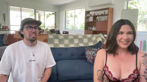 Media: Video of a white couple in a living room; man in white shirt, woman in red lace bra, smiling.