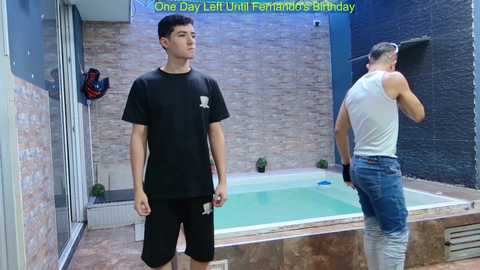 Video of two men: one in black workout gear, the other in a white tank top and jeans, standing near a small, green indoor pool in a modern, tiled room. Text overlay reads, \"One Day Last Week Until Fernand's Birthday.\