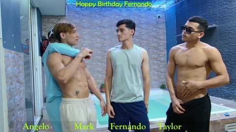 Media: Video of three shirtless men in a modern indoor pool area, Mark, Angel, and Fernando, with Mark holding a towel, Angel in a white tank, and Fernando in black pants.