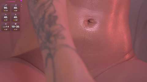 Media: Video of a close-up view of a woman's nude torso, featuring a small areola and nipple, with visible tattoos on her arm. Background shows a digital health monitoring app with temperature and heart rate readings.