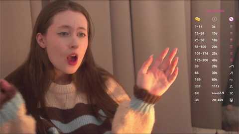 A video of a young girl with fair skin and long brown hair, wearing a striped sweater, reacting with surprise. A virtual reality headset displays a grid of numbers in the background.