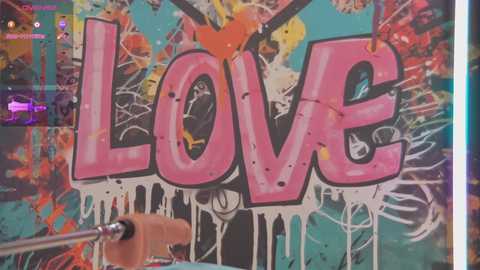 Media: A vibrant video shows a spray-painted wall with \"LOVE\" in bold pink letters dripping with white paint, surrounded by colorful abstract art and graffiti. A hand with a paintbrush is visible on the left, adding to the energetic, artistic atmosphere.