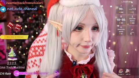 Media: A video of a light-skinned woman in a Santa costume, with long silver hair, elf ears, and freckles, smiling. The background features Christmas decorations and social media icons.