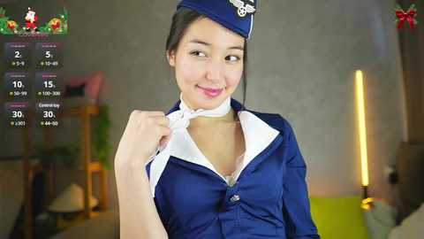 Media: Video of a young Asian woman in a sexy flight attendant costume, unbuttoned blouse revealing cleavage, in a dimly lit room.