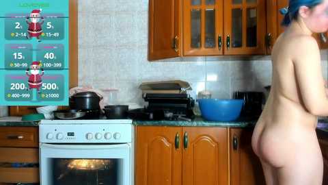 Media: Video of a nude woman with blue hair, standing in a kitchen with wooden cabinets, stove, and countertop cluttered with food items and cooking utensils.