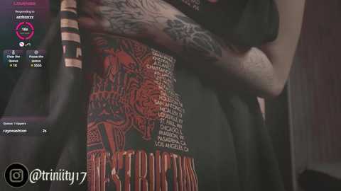 Media: A close-up video of a tattooed person, showcasing a detailed, colorful tattoo on their side, with an arm partially visible. The background is dimly lit, and the image includes a watermark and social media icons.