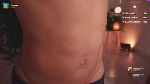 Media: Video of a fair-skinned man's bare stomach, showing a slight belly button, with a soft, dimly-lit background featuring a candlelit room and a water bottle.