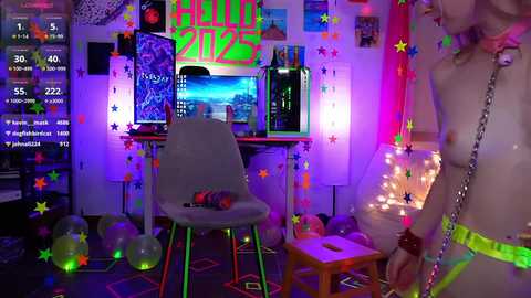 Media: Video of a vibrant, neon-lit room with a white chair, TV, and computer, featuring a person in neon green shorts, starry decor, and colorful lights.