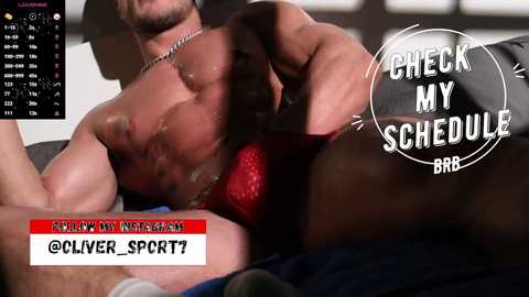 Media: Video: Muscular, shirtless man with dark skin, holding a red, textured object against his chest. Text overlay reads \"CHECK MY SCHEDULE\" and \"PUBLISHER SPORT7.\