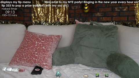 Media: Video of a living room with a white couch, red and green pillows, a brick wall, and a metallic curtain. Text overlays the image with tips for New Year's Eve.