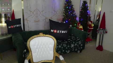 Media: A video of a festive living room with a green velvet couch adorned with \"MOST BEAUTIFUL\" pillows and Christmas decorations, including a decorated tree, presents, and reindeer figurines.