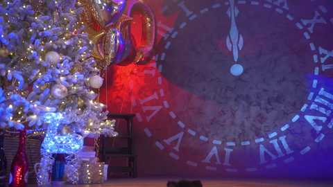 Media: Video of a festive room with a decorated Christmas tree on the left, red and blue lighting, and a clock wall with Roman numerals on the right.