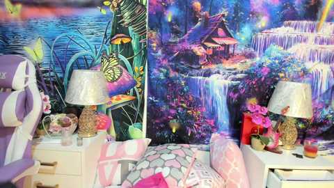 Media: Video of a colorful, whimsical bedroom with a vibrant, detailed tapestry backdrop featuring a tropical waterfall scene. The room includes a bed with pink and white geometric-patterned bedding, two nightstands with lamps, and a hanging purple bag.