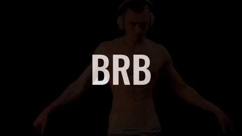 Media: Video of a shirtless, muscular man with headphones, standing against a black background. Large white letters spell \"BBB\" over his torso. The man's expression is serious, and his body posture is relaxed.