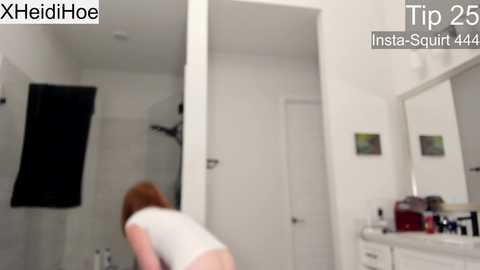 Media: Video of a bathroom with a white-tiled wall and a person bending over, partially obscured by a towel.