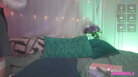 Media: A video of a cozy bedroom with a bed adorned with green pillows and a white canopy. The room features a pink Hello Kitty plush, a vase of purple flowers, and a green lamp.