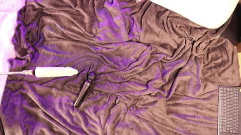 Media: A video shows a brown, silky fabric with a purple dye stain, a white paintbrush, and a partially visible keyboard in the background.