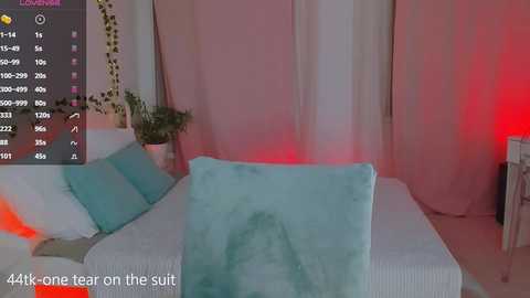 Media: Video of a bedroom with white bed, turquoise blankets, pink curtains, red light, and digital stats in the corner.