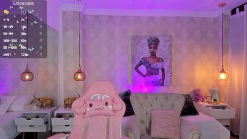 Media: A video of a modern, pink-themed bedroom with a plush chair, gold elephant statues, and a framed portrait on a tufted headboard. Purple lighting and hanging pendant lights add ambiance.