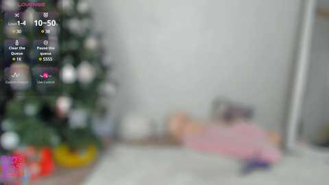 Media: A blurred, out-of-focus video of a woman lying on a pink bedspread in a bedroom, with a Christmas tree visible on the left.