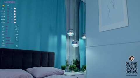 Media: Video of a modern bedroom with teal walls, a black upholstered headboard, and three pendant lights. The room features a minimalist design with white pillows and a framed sketch on the wall.